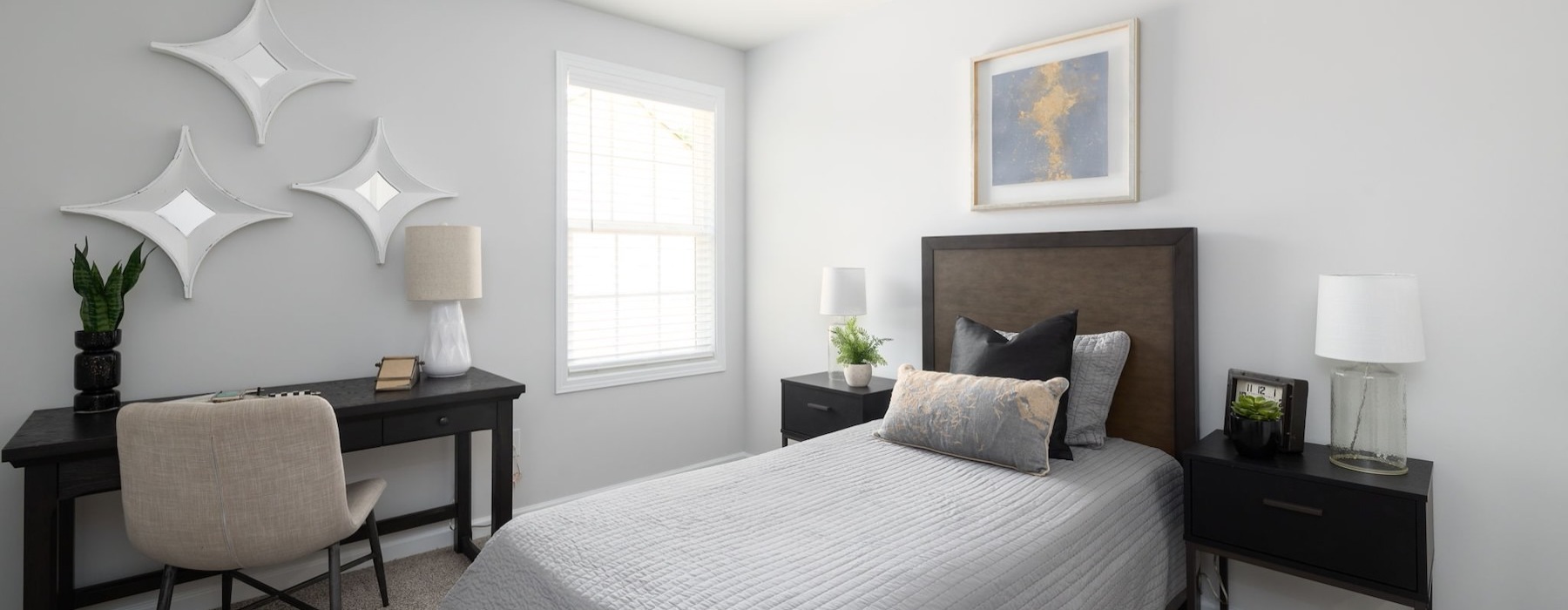 a bedroom with a bed, desk and chair